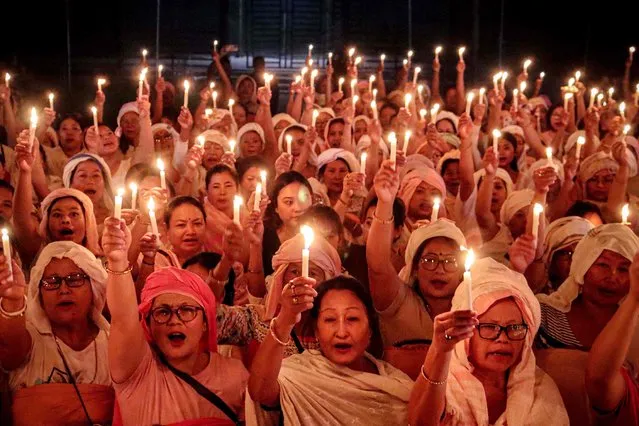 In this photograph taken on October 2, 2023, women take part in a candlelight vigil in Imphal, to honour those who lost their lives in the ongoing ethnic clashes in India's Manipur state. (Photo by AFP Photo/Stringer)