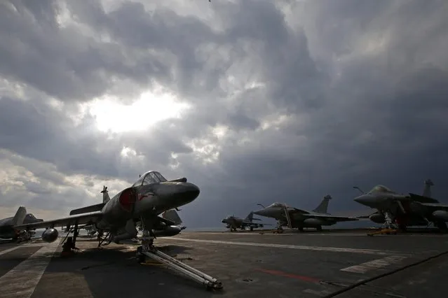 A Super Etendard (L) and Rafale (R) fighter jets are parked aboard France's Charles de Gaulle aircraft carrier during its mission in the Gulf, January 29, 2016. (Photo by Philippe Wojazer/Reuters)