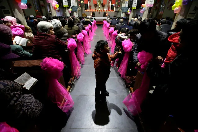 A 5-year-old boy plays during a Christmas eve mass at a Catholic church on the outskirts of Taiyuan, North China's Shanxi province, December 24, 2016. (Photo by Jason Lee/Reuters)