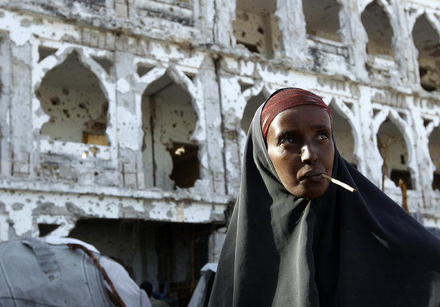 Somali's decades of political upheaval and crippling poverty has given rise to various radical Islamist groups. Here: a woman stands in front of a building destroyed during a fight between al Shabaab militants against African Union and Somali Government forces in Mogadishu June 26, 2012. (Photo by Goran Tomasevic/Reuters)