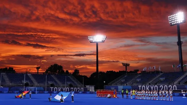 Players of Spain (L) and Argentina listen to their anthems before the start of their women's pool B match of the Tokyo 2020 Olympic Games field hockey competition, at the Oi Hockey Stadium in Tokyo on July 26, 2021. (Photo by Bernadett Szabo/Reuters)