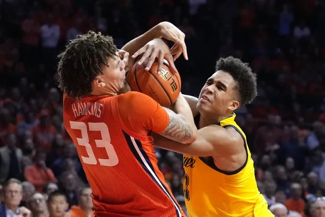 Illinois forward Coleman Hawkins (33) fouls Marquette forward Oso Ighodaro as he tries to wrestle the ball from Ighodaro during the second half of an NCAA college basketball game Tuesday, November 14, 2023, in Champaign, Ill. (Photo by Charles Rex Arbogast/AP Photo)