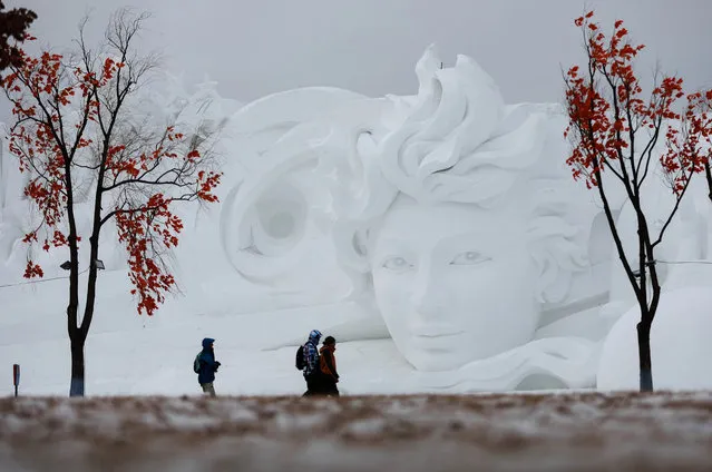 People walk past a snow sculpture in Harbin in China's northeastern Heilongjiang province on January 4, 2019. (Photo by AFP Photo/China Stringer Network)