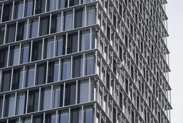 Free-solo climber George King climbs the Stratosphere Tower building, a 36-story residential tower block in Stratford, east London Tuesday, August 3, 2021. In 2019, George King was sentenced to six months' custody after admitting breaching a High Court injunction when he scaled The Shard – one of the tallest buildings in Europe. (Photo by Yui Mok/PA Wire via AP Photo)