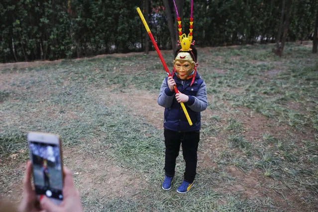 A boy wearing a mask poses for pictures as the Chinese Lunar New Year, which welcomes the Year of the Monkey, is celebrated at the temple fair at Ditan Park (the Temple of Earth), in Beijing, China February 11, 2016. (Photo by Damir Sagolj/Reuters)