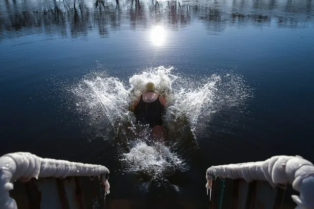 A winter swimming enthusiast dives into a lake in Shenyang, in northeastern China's Liaoning province on November 24, 2023. (Photo by AFP Photo/China Stringer Network)