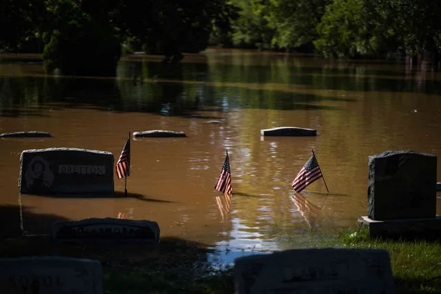 Headstones at a cemetery that flooded are seen in Somerville, N.J. Thursday, September 2, 2021. A stunned U.S. East Coast faced a rising death toll, surging rivers, tornado damage and continuing calls for rescue Thursday after the remnants of Hurricane Ida walloped the region with record-breaking rain, drowning more than two dozen people in their homes and cars. (Photo by Eduardo Munoz Alvarez/AP Photo)