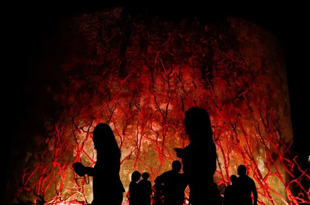 People walk in front of an art installation called “L'albero di corallo” (Coral tree), in Alghero, Italy, September 25, 2021. (Photo by Yara Nardi/Reuters)