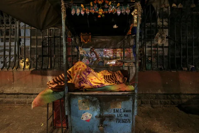 A man sleeps on a roadside stall early morning in Mumbai, India, March 6, 2019. (Photo by Francis Mascarenhas/Reuters)