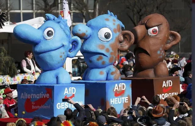 A carnival float with papier-mache caricatures featuring a member of Germany's AfD party metamorphosing from a blue to a brown character, is displayed at a postponed “Rosenmontag” (Rose Monday) parade, at one location in Duesseldorf, Germany, March 13, 2016, after the original parade in February was cancelled due to severe weather.  Words read (L-R) “Yesterday. Today. Tomorrow”. (Photo by Ina Fassbender/Reuters)