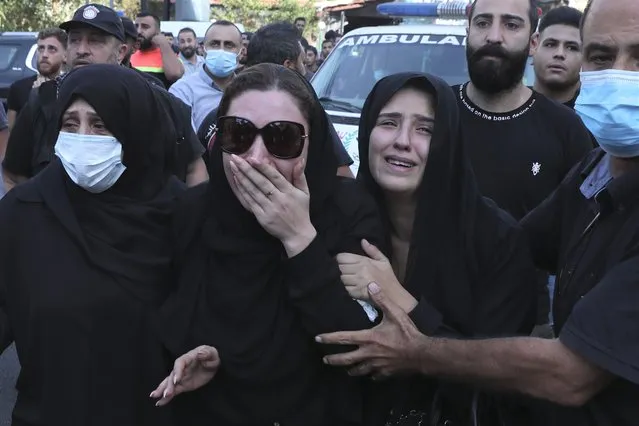 Family of Hassan Jamil Nehmeh mourn during his funeral processions in the southern Beirut suburb of Dahiyeh, Lebanon, Friday, October 15, 2021. The government called for a day of mourning following the armed clashes, in which gunmen used automatic weapons and rocket-propelled grenades on the streets of the capital, echoing the nation’s darkest era of the 1975-90 civil war. (Photo by Bilal Hussein/AP Photo)