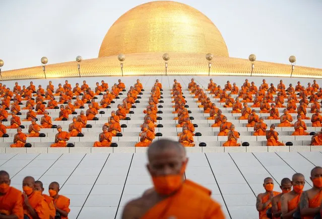 Thai Buddhist monks chant during the mass morning alms-giving ceremony to mark the start of the new year at Wat Phra Dhammakaya Temple in Pathum Thani province, Thailand, 01 January 2024. Thousands of devotees gathered in a morning almsgiving ceremony to offer foods and essentials to more than 3,000 Buddhist monks to mark the start of 2024 new year, the year of the dragon. (Photo by Rungroj Yongrit/EPA)