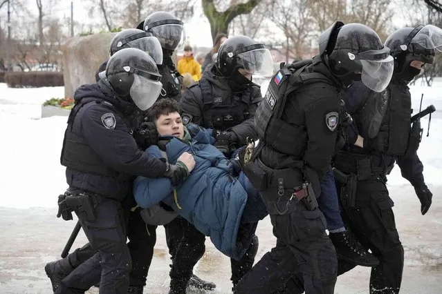 Police detain a man as he wanted to lay flowers paying their last respect to Alexei Navalny at the monument, a large boulder from the Solovetsky islands, where the first camp of the Gulag political prison system was established, in St. Petersburg, Russia on Saturday, February 17, 2024. (Photo by AP Photo)