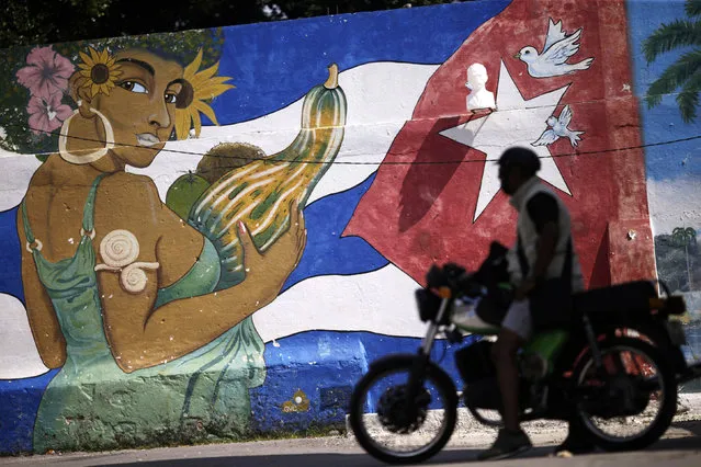 A motorcyclist drives past a mural painting in Havana, Cuba March 18, 2016. (Photo by Ueslei Marcelino/Reuters)