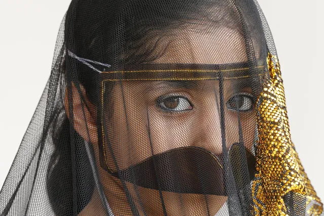 An Emirati girl wears a traditional outfit, worn in her village by elderly women, during the al-Gharbia Watersports festival poses near al-Mirfa beach, outside Abu Dhabi, on May 2, 2015. (Photo by Karim Sahib/AFP Photo)