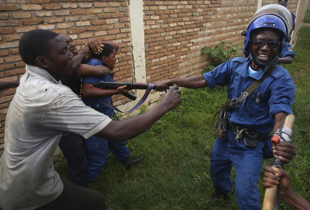 A mob attacks a female police officer accused of shooting a protester in the Buterere neighborhood of Bujumbura, Burundi, May 12, 2015. (Photo by Goran Tomasevic/Reuters)