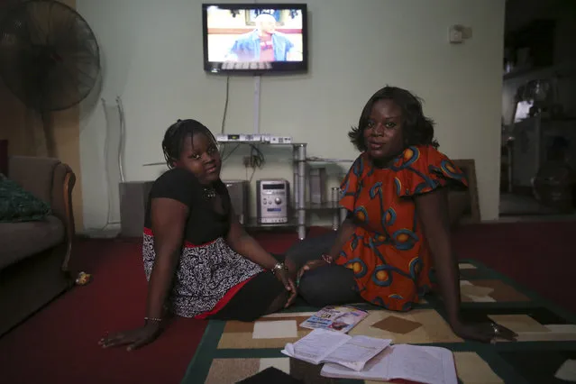 Adetola Ibitoye, 39, sits with her daughter Iteoluwa Ibitoye, 9, in their home in Omole district, Lagos February 16, 2014. When Adetola was growing up, she wanted to run a fashion business. Now she is a clothes designer. Adetola says she wants her daughter to be the best at whatever she sets her mind to be. Her daughter Iteoluwa says she wants to grow up to be a university teacher. (Photo by Akintunde Akinleye/Reuters)