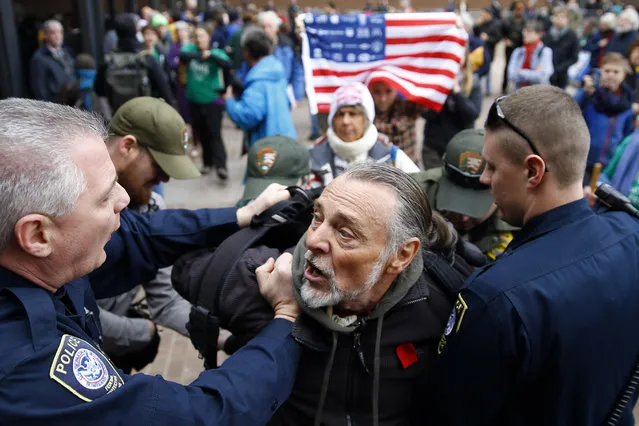 Police detain a protester demonstrating in opposition to the proposed Keystone XL oil pipeline, Monday, March 10, 2014, outside the Federal Building in Philadelphia. The protestors say the pipeline would contribute to global warming. (Photo by Matt Rourke/AP Photo)