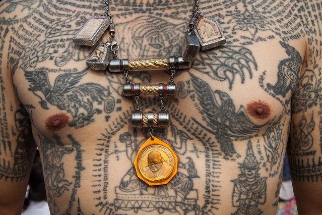 A Thai devotees shows his body tattoos during the celebration of the annual Tattoo festival at Wat Bang Phra on March 15, 2014 in Nakhon Pathom, Thailand.  Thousands of believers from all over Thailand come to take part in one of the country's most bizarre festivals about 50 miles outside Bangkok to pay respect to the temple's monks who are master tattooist. In Thai culture the tattoo is worn as a symbol of spiritual and physical protection, many believe that the tattoo has mystical powers. (Photo by Omar Havana/Getty Images)