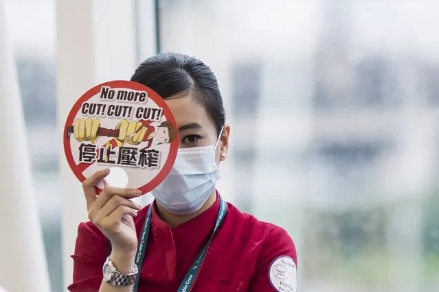 A Cathay Pacific flight attendant carries a sign while participating in a protest at the departure hall of the Hong Kong Airport, China May 19,2015. (Photo by Tyrone Siu/Reuters)