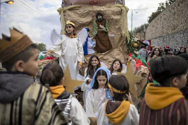 Israeli Arab Christians wear traditional costume waits for the start of the annual Christmas parade in Nazareth, Israel, Friday, December 24, 2021. (Photo by Ariel Schalit/AP Photo)