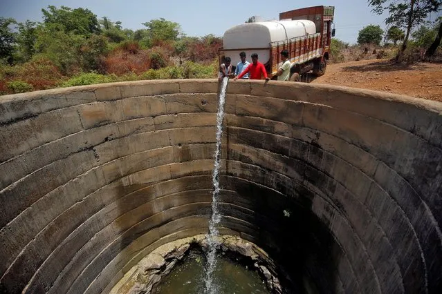 A dried-up well is refilled with water from a water tanker in Thane district in Maharashtra, May 30, 2019. (Photo by Francis Mascarenhas/Reuters)
