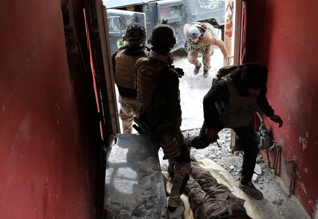 Iraqi special forces soldiers run inside a house during a battle with Islamic State militants in Mosul, Iraq March 3, 2017. (Photo by Goran Tomasevic/Reuters)