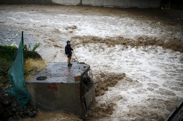 A man is seen next to a river during floods in Santiago, April 17, 2016. (Photo by Ivan Alvarado/Reuters)