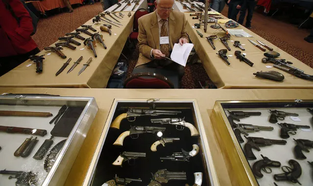 Antique gun collector Dave Kleiner reviews paperwork during the East Coast Fine Arms Show in Stamford, Connecticut, January 5, 2013. (Photo by Carlo Allegri/Reuters)