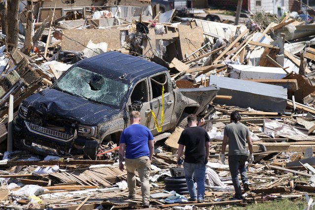 Local residents walk among the debris from tornado damaged homes in Greenfield, Iowa, on Wednesday, May 22, 2024. (Photo by Charlie Neibergall/AP Photo)