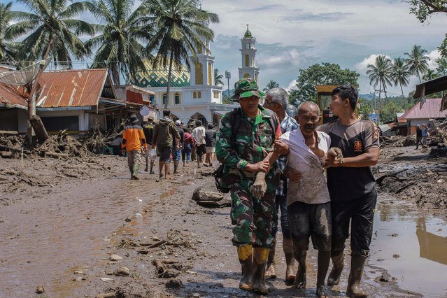 Rescuers evacuate an injured man through mud flooded area following a flash flood in Tanah Datar, West Sumatra, Indonesia, 12 May 2024. (Photo by Givo Alputra/EPA/EFE/Rex Features/Shutterstock)