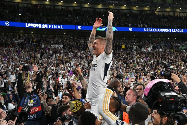 Real Madrid's German midfielder #08 Toni Kroos (C) celebrates with supporters after the victory at the end of the UEFA Champions League final football match between Borussia Dortmund and Real Madrid, at Wembley stadium, in London, on June 1, 2024. (Photo by Glyn Kirk/AFP Photo)