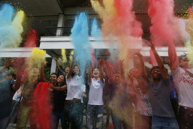Lovi Poe, center, the sister of presidential candidate Grace Poe, leads the symbolic throwing of colored powder as her sister is endorsed by “Kabataan” party-list group, a youth organization trying to campaign for a seat in the Lower House, Thursday, May 5, 2016, at suburban Quezon city northeast of Manila, Philippines. Poe is running second to front-running candidate Rodrigo Duterte in recent poll surveys leading to Monday's Presidential elections. (Photo by Bullit Marquez/AP Photo)