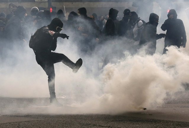 A protester kicks back a teargas grenade during a demonstration against French labour law reform in Paris, France, May 12, 2016. (Photo by Gonzalo Fuentes/Reuters)