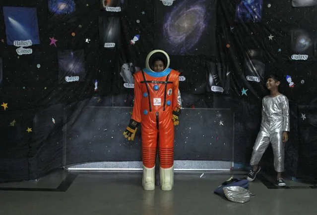 School children try on a space suit during an exhibition on space technology organised by Indian Space Research Organisation (ISRO) and a college in Mumbai, India, September 18, 2019. (Photo by Prashant Waydande/Reuters)