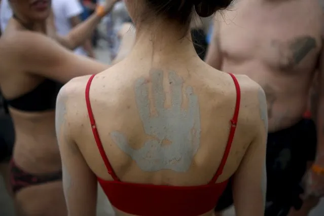 A hand print is seen on the back of a tourist during the Boryeong Mud Festival at Daecheon beach in Boryeong, South Korea, July 18, 2015. (Photo by Kim Hong-Ji/Reuters)