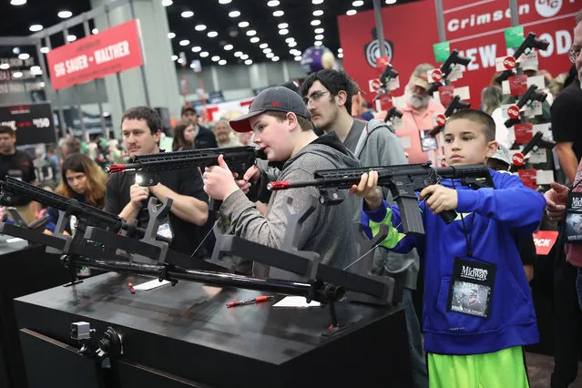 Gun enthusiasts try out the Crimson Trace laser sighting systems at the NRA Annual Meetings & Exhibits on May 21, 2016 in Louisville, Kentucky. About 80,000 visitors are expected to attend the three-day event. (Photo by Scott Olson/Getty Images)