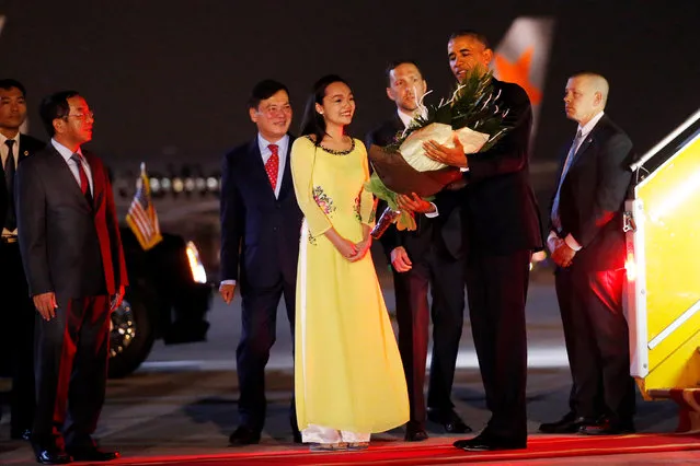 U.S. President Barack Obama receives flowers as he arrives at Noibai International Airport in Hanoi, Vietnam May 22, 2016. (Photo by Carlos Barria/Reuters)