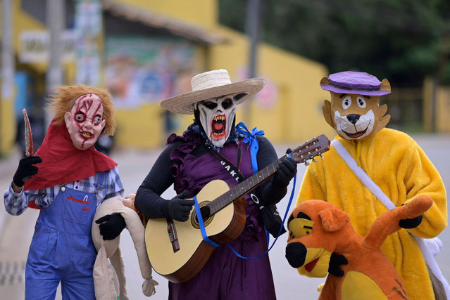 Revellers in costumes take part in the Masquerade Party (Festa dos Mascarados), a traditional Easter celebration held in Brazil to celebrate the end of Holy Week, in Jaboticatubas, state of Minas Gerais, Brazil, on April 9, 2023. As Holy Week celebrations come to an end, people attending the Masquerade Party get dressed in shabby clothes and costumes and wear masks for the traditional “burning of Judas”, the biblical figure who supposedly betrayed Jesus, and his fictional wife Sabina. (Photo by Douglas Magno/AFP Photo)