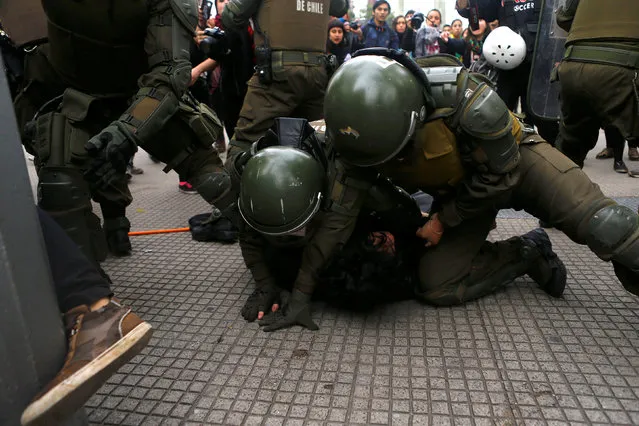 A demonstrator is detained during an unauthorized march called by secondary students to protest against government education reforms in Santiago, Chile, May 26, 2016. (Photo by Ivan Alvarado/Reuters)