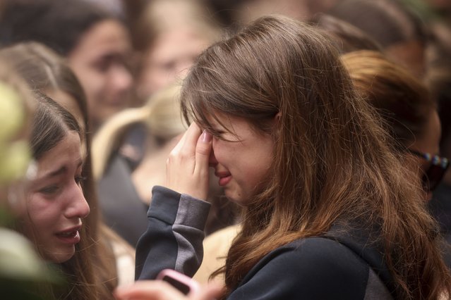 A woman cries as people light candles for the victims near the Vladislav Ribnikar school in Belgrade, Serbia, Thursday, May 4, 2023. A 13-year-old who fire Wednesday at his school in Serbia's capital. He killed eight fellow students and a guard before calling the police and being arrested. Six children and a teacher were also hospitalized. (Photo by Armin Durgut/AP Photo)