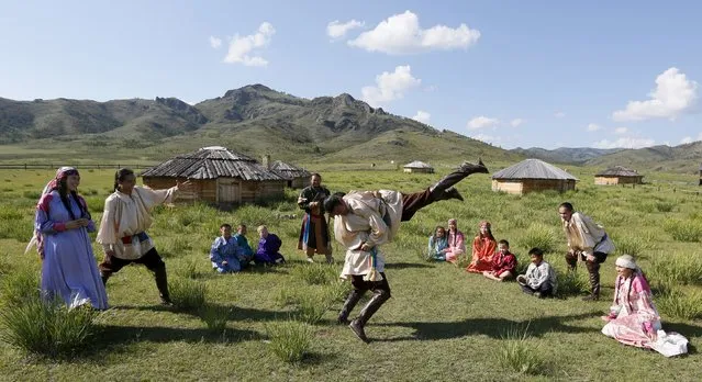 Members of national folklore and ethnographic groups and employees of a museum-reserve participate in the reconstruction of daily life and traditional holidays celebrated by indigenous population of the Republic of Khakassia during a demonstration for visitors outside Kazanovka village, southwest of the city of Abakan, Russia, July 24, 2015. (Photo by Ilya Naymushin/Reuters)