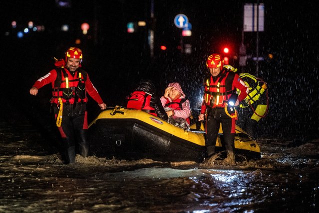 Firemen and civil protection rescuers evacuate a woman with an inflatable boat in Forli on May 17, 2023 after heavy rains have caused major floodings in central Italy, where trains were stopped and schools were closed in many towns while people were asked to leave the ground floors of their homes and to avoid going out. (Photo by Alessandro Serrano/AFP Photo)