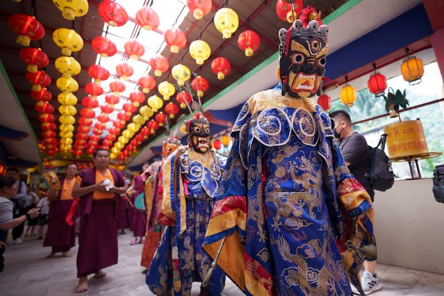 Monks wearing magnificent costumes and masks perform parade in the temple before the Thangka, or traditional painting of Lord Buddha, is unveiled at a Tibetan temple during Wesak day celebration in Ipoh, Malaysia, Wednesday, May 22, 2024. Wesak Day, one of the holiest days for Buddhists, offers an opportunity for all followers to come together and celebrate not only Buddha's birthday, but also his enlightenment and achievement of nirvana. (Photo by Vincent Thian/AP Photo)