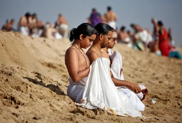 People perform special prayers during the annular solar eclipse and for the victims of the 2004 tsunami on the 15th anniversary of the disaster, at Marina beach in Chennai, December 26, 2019. (Photo by P. Ravikumar/Reuters)