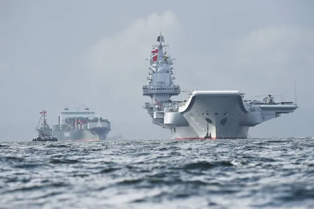 China's sole aircraft carrier, the Liaoning (R), arrives in Hong Kong waters on July 7, 2017, less than a week after a high-profile visit by president Xi Jinping. China's national defence ministry had said the Liaoning, named after a northeastern Chinese province, was part of a flotilla on a “routine training mission” and would make a port of call in the former British colony. (Photo by Anthony Wallace/AFP Photo)