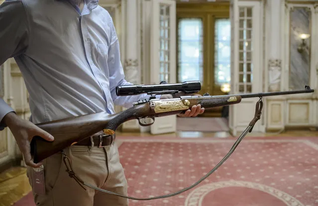 Cristian Gavrila, collectibles consignment manager at Artmark auction house, holds the late Communist leader Nicolae Ceausescu's Holland & Holland hunting rifle before an auction, in Bucharest, Romania, Tuesday, July 11, 2017. Romanian Communist leader Nicolae Ceausescu was an avid hunter, and his most treasured gun, a Holland & Holland hunting rifle, is to be auctioned. (Photo by Andreea Alexandru/AP Photo)
