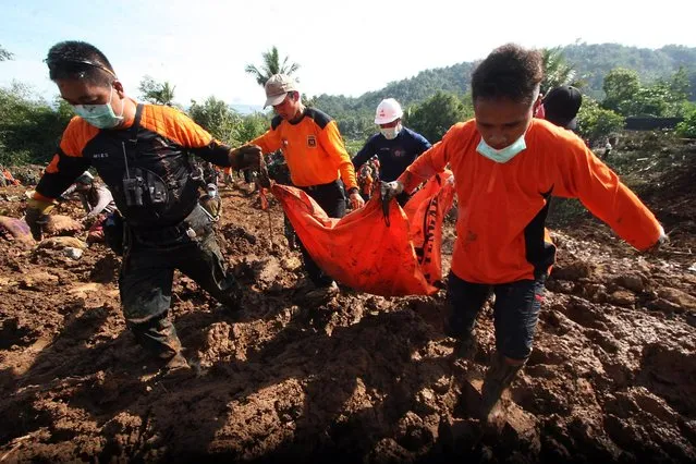 Indonesian rescuers carry the body of a victim at the site of a landslide at Caok Village in Purworejo, Central Java, Indonesia, 21 June 2016. Floods and landslides have hit Central Java over the past few days killing more than 20 people and leaving dozens missing, according to media reports. (Photo by Boy Triharjanto/EPA)