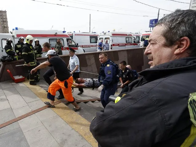 Members of the emergency services carry an injured passenger outside a metro station following an accident on the subway in Moscow July 15, 2014. (Photo by Sergei Karpukhin/Reuters)