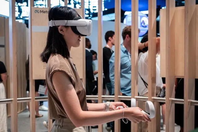 An attendee tries out a Meta virtual reality headset during the Vivatech technology startups and innovation fair in Paris on May 15, 2022. (Photo by Bertrand Guay/AFP Photo)